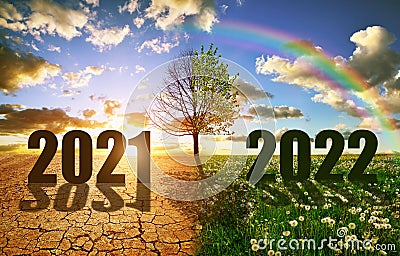 Number 2021 in dry country with cracked soil and 2022 in the green grass. Stock Photo