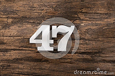 Number forty seven 47 - White Piece on Rustic Wood Background Stock Photo