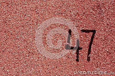 number fourty seven on red plaster wall. Stock Photo