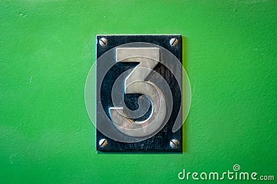 Number 3 sign - number three metal sign on green background Stock Photo