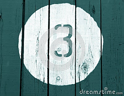 Number three on wooden cyan toned wall. Stock Photo