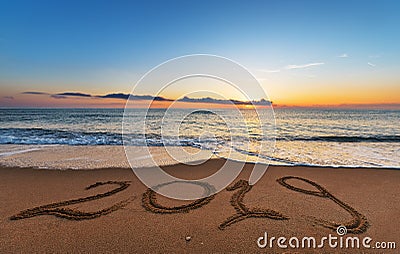 Number 2019 written on seashore sand at sunrise. Stock Photo