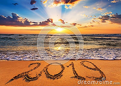 Number 2019 written on seashore sand at sunrise. Stock Photo