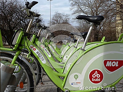 Rentable green city bucycles offered by MOL in diminishing perspective in Budapest, Hungary Editorial Stock Photo