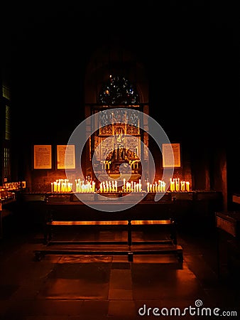 Numerous candles enlight the solemn catholic chapel`s altar Stock Photo