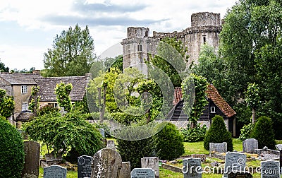 Nunney Castle with church grave yard in the foreground in Nunney, Somerset, UK Editorial Stock Photo