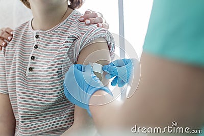 Nurse applying bandage on boy arm at hospital Stock Photo