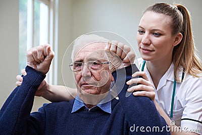 Nurse Assessing Stroke Victim By Raising Arms Stock Photo