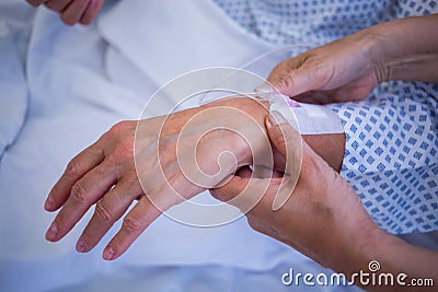 Nurse attaching iv drip on patient s hand Stock Photo