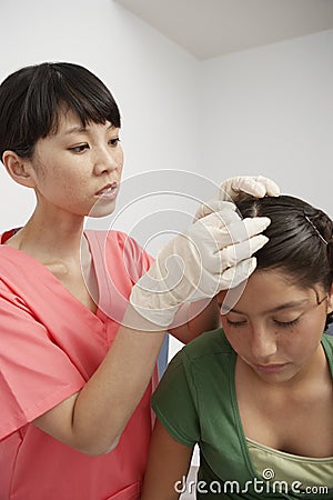 Nurse Checking Girl's Head Stock Photo