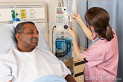 Nurse Checking Senior Patient's IV Drip On Ward Stock Photo