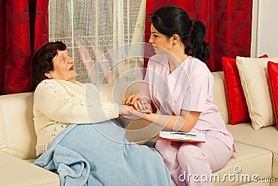 Nurse comforting sick elderly woman Stock Photo