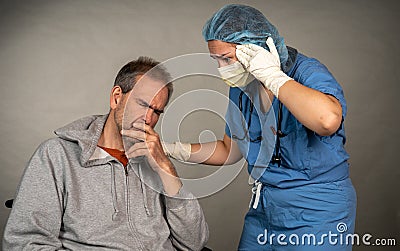Nurse comforts a sick older man Stock Photo