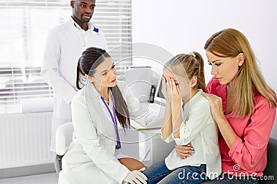nurse female doctor general practitioner talks and amuses child before medical examination Stock Photo