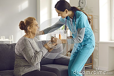 Nurse giving glass of water to senior woman at home, clinic or assisted living facility Stock Photo