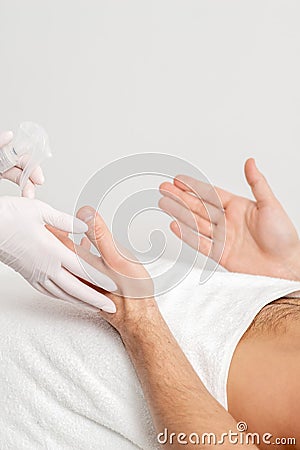 Nurse hand sanitizing hands of male patient Stock Photo