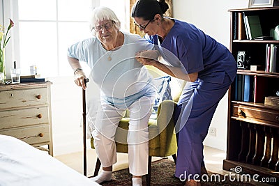 Nurse helping senior woman to stand Stock Photo