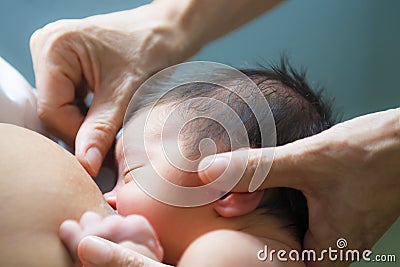 Nurse heps a mother breastfeeding her newborn baby Stock Photo