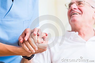 Nurse holding hand of senior man in rest home Stock Photo