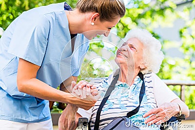 Nurse holding hand of senior woman in pension home Stock Photo