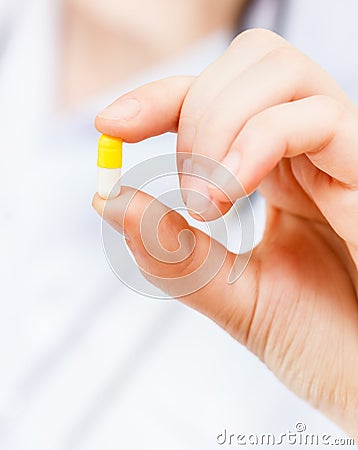 Nurse holds pilule in finger Stock Photo