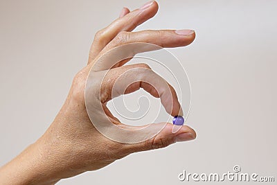 The nurse holds purple tablets in her fingers to indicate plaque Stock Photo