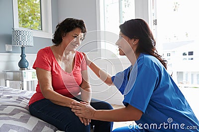 Nurse Making Home Visit To Senior Hispanic Woman Stock Photo