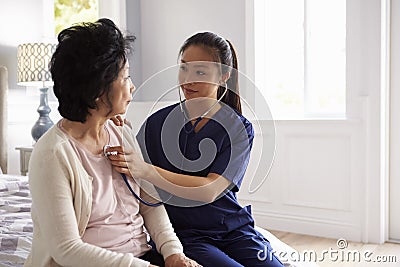 Nurse Making Home Visit To Senior Woman For Medical Exam Stock Photo
