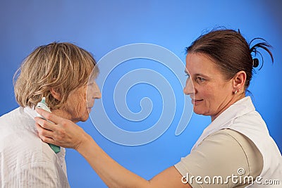 Nurse measures fever of elderly woman Stock Photo