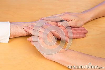 Nurse measures pulse of elderly woman Stock Photo