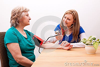 Nurse measures senior the blood pressure Stock Photo