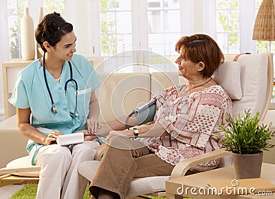 Nurse measuring blood pressure Stock Photo