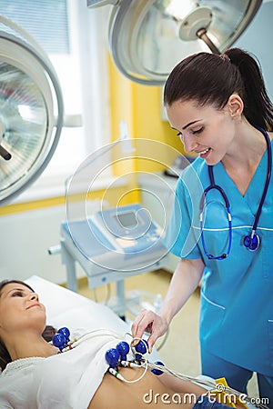 Nurse performing an electrocardiogram test on the patient Stock Photo