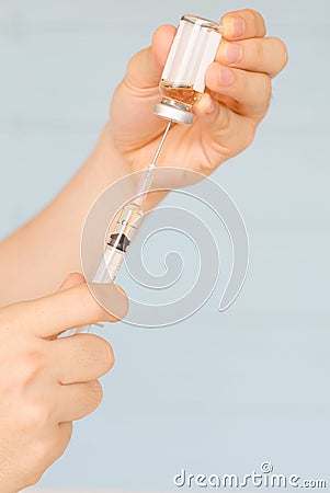 Nurse prepares to draw medication from glass vial Stock Photo