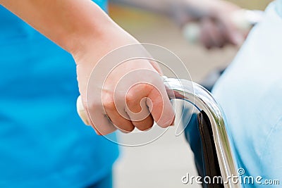 Nurse Pushing Wheelchair Stock Photo