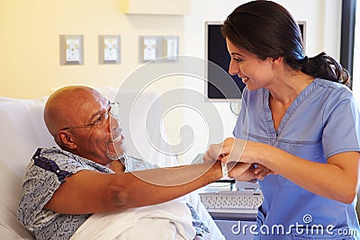 Nurse Putting Wristband On Senior Male Patient In Hospital Stock Photo