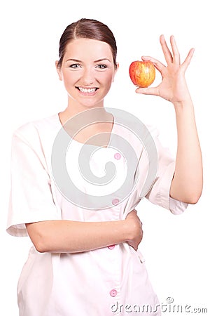 Nurse smiling and holding up an apple Stock Photo