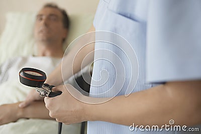 Nurse Taking Blood Pressure And Pulse Of Patient Stock Photo