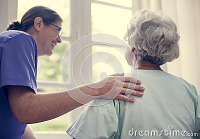 Nurse taking care of an old woman Stock Photo