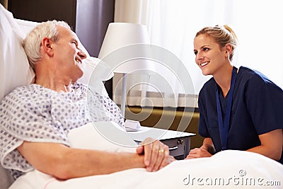 Nurse Talking To Senior Male Patient In Hospital Bed Stock Photo