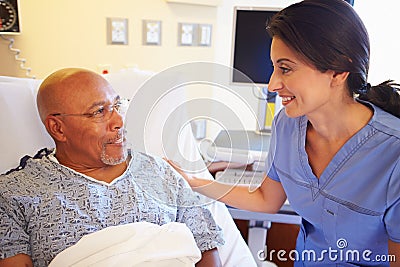 Nurse Talking To Senior Male Patient In Hospital Room Stock Photo