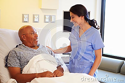 Nurse Talking To Senior Male Patient In Hospital Room Stock Photo