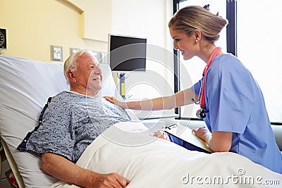 Nurse Talking To Senior Male Patient In Hospital Room Stock Photo