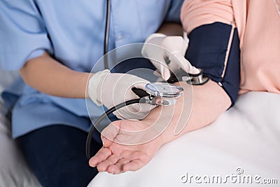 Nurse using blood pressure meter Stock Photo