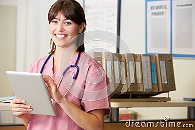 Nurse Using Digital Tablet At Nurses Station Stock Photo