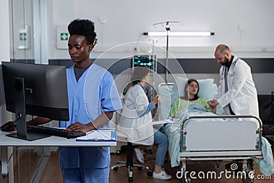 Nurse using personal computer to complete patient admission chart and read medical history Stock Photo