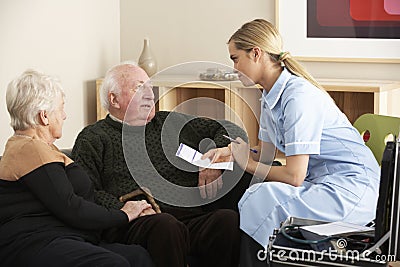 Nurse visiting senior couple at home Stock Photo