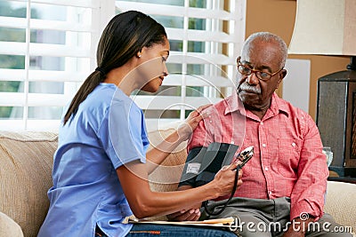 Nurse Visiting Senior Male Patient At Home Stock Photo