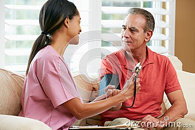 Nurse Visiting Senior Male Patient At Home Stock Photo