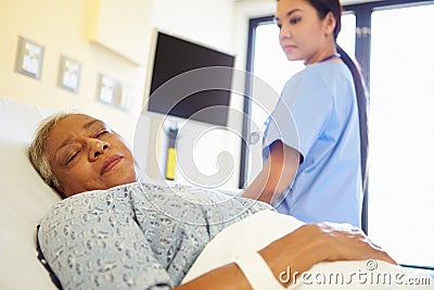 Nurse Watching Sleeping Senior Woman Patient In Hospital Stock Photo